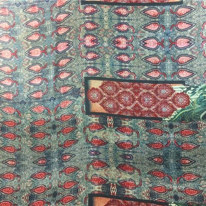 Puede incluir: Una tela con estampado azul y rojo con un diseño repetitivo de hojas estilizadas. La tela presenta un diseño más grande de un rectángulo con estampado rojo y dorado y un pájaro con estampado verde y dorado.