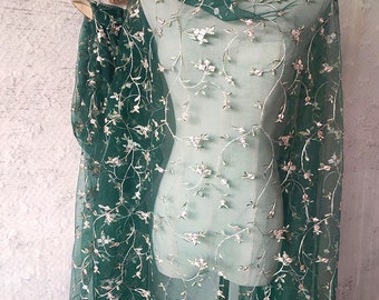 May include: Green sheer fabric with embroidered floral vines in silver and pink.