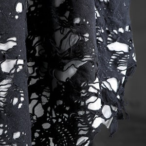 May include: Black fabric with a distressed, ripped, and frayed design. The fabric has a lace-like appearance with large holes throughout.