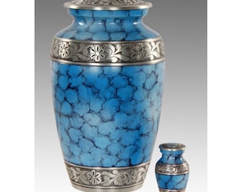 May include: A blue and silver cremation urn with a floral design. The urn is made of metal and has a marbled finish. It is a traditional style urn with a lid.