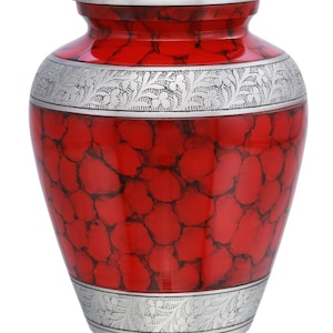 May include: Red and silver cremation urn with a floral design. The urn has a marbled effect and a silver lid.