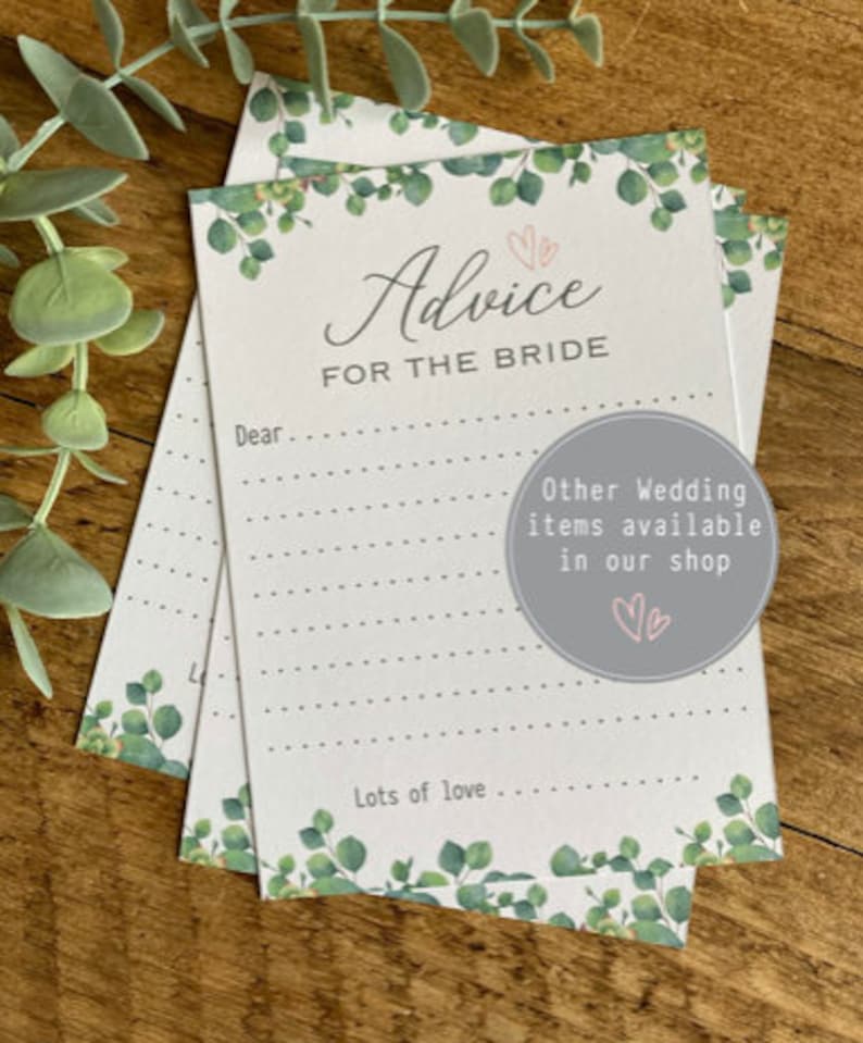 May include: A white card with a green leafy border and the text "Advice for the Bride" in a cursive font. The card has lines for writing and the text "Lots of love..." at the bottom. The card also has a small circle with the text "Other Wedding items available in our shop" and two pink hearts.