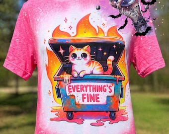 May include: Pink t-shirt with a graphic of a cat in a dumpster surrounded by flames. The dumpster has the text "EVERYTHING'S FINE". The shirt also has a "Whiskey Witch" graphic.