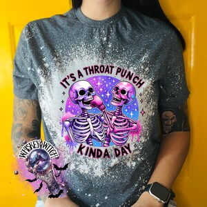 May include: A gray t-shirt with a bleach-splattered design featuring two skeletons wearing boxing gloves. The text "It's a throat punch kinda day" is printed on the shirt.