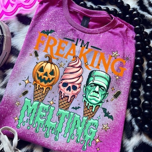 Spooky summer graphic tee featuring pumpkin, skull, and Frankenstein ice cream cones with bright orange and green lettering.