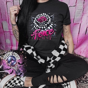 May include: A black t-shirt with a black and white striped rose with a pink center and the word "Fierce" in pink dripping down the rose.