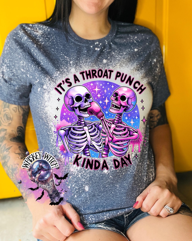 May include: A gray t-shirt with a bleach-splattered design featuring two skeletons boxing. The text "It's a throat punch kinda day" is printed on the shirt.