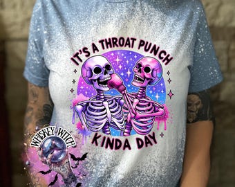 May include: A blue bleached t-shirt with a graphic of two skeletons wearing boxing gloves and the text "It's a throat punch kinda day".