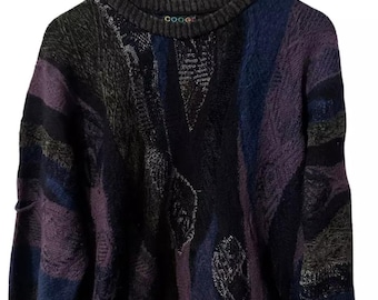 May include: A multi-colored knit sweater with a geometric pattern in shades of purple, blue, black, and green. The sweater has a crew neck and long sleeves. The brand name "COOGI" is visible on the front of the sweater.