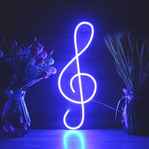 Può includere: Un'insegna a forma di chiave di violino al neon blu brillante. Il simbolo musicale è illuminato su uno sfondo scuro, con vasi di fiori e spighe di grano su entrambi i lati. L'insegna è un elemento decorativo.