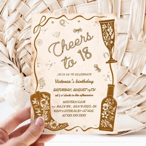 Puede incluir: Una invitaci&oacute;n de color beige con ilustraciones y texto en marr&oacute;n. El dise&ntilde;o incluye una bota de vaquero, una copa de champ&aacute;n y una botella. El texto dice "Cheers to 18" e invita al cumplea&ntilde;os de Victoria.