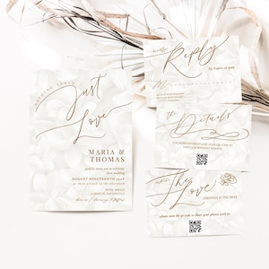 May include: Elegant wedding invitation suite featuring a floral design and gold script. The main invitation reads "Just Love" with the names Maria & Thomas. Includes reply, details, and thank you cards. QR codes are included.