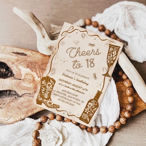 Puede incluir: Una tarjeta de invitaci&oacute;n de color beige con ilustraciones y texto en marr&oacute;n. La tarjeta anuncia una fiesta de cumplea&ntilde;os con las palabras "Cheers to 18". Las ilustraciones incluyen una bota de vaquero, una copa de champ&aacute;n y una botella.