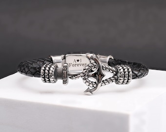 May include: A black leather bracelet with a silver anchor charm and a personalized inscription that reads "A♥J Forever".