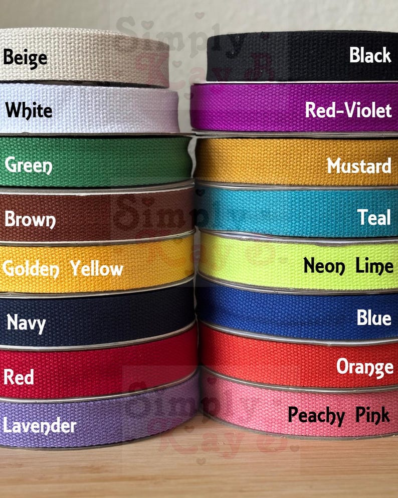 May include: Two stacks of woven cotton webbing ribbon in various colors including beige, white, green, brown, golden yellow, navy, red, lavender, black, red-violet, mustard, teal, neon lime, blue, orange, and peachy pink.