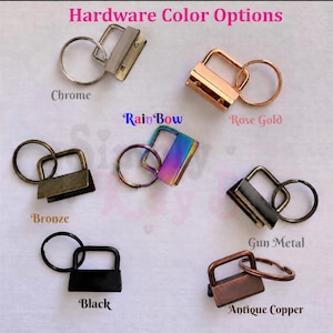 May include: Hardware color options for key fobs, featuring seven metal clips with attached split rings in chrome, rose gold, bronze, rainbow, gun metal, black, and antique copper finishes. The text Hardware Color Options is at the top.