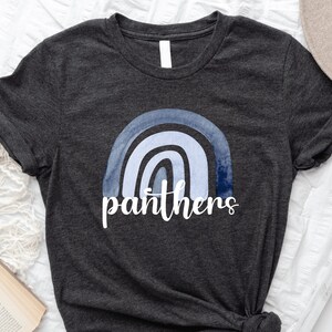 May include: A dark grey t-shirt with a blue watercolor rainbow and the word "panthers" printed on the front.