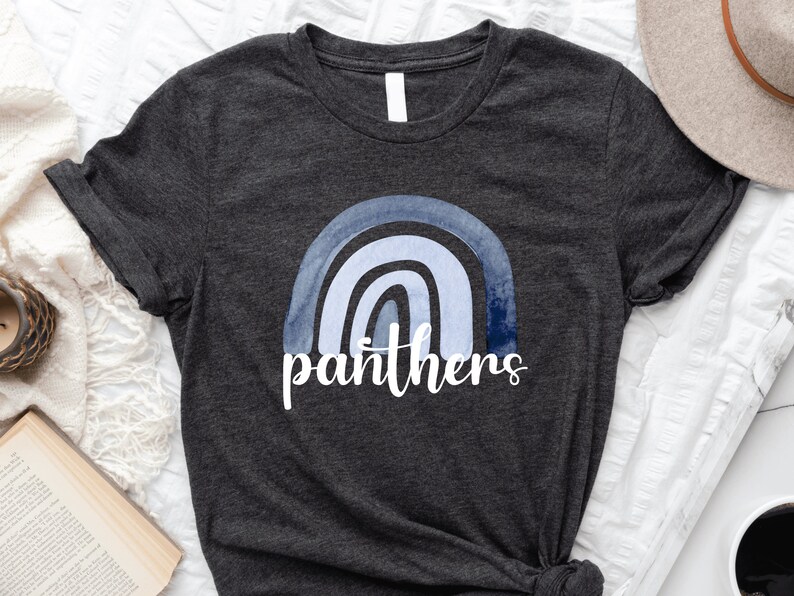 May include: A dark grey t-shirt with a blue watercolor rainbow and the word "panthers" printed on the front.