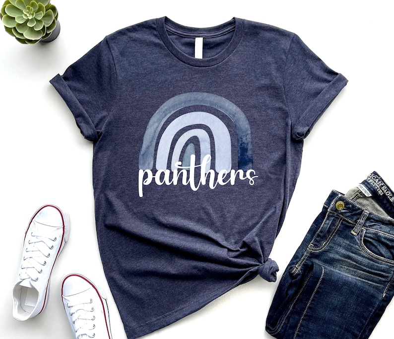 May include: A navy blue t-shirt with a watercolor rainbow design and the word "panthers" in white text.