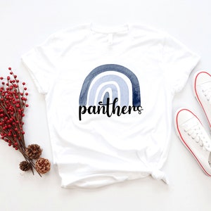May include: White t-shirt with a blue watercolor rainbow and the word "panthers" in black lettering.