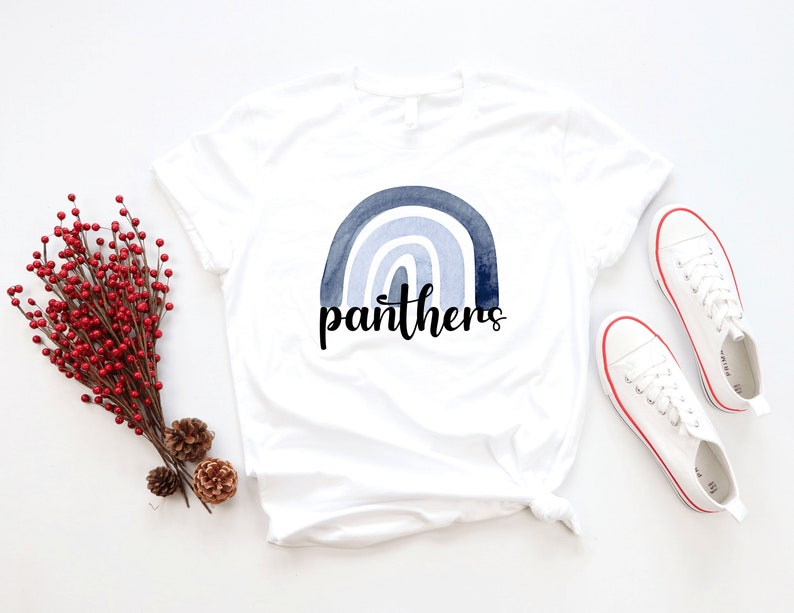 May include: White t-shirt with a blue watercolor rainbow and the word "panthers" in black lettering.