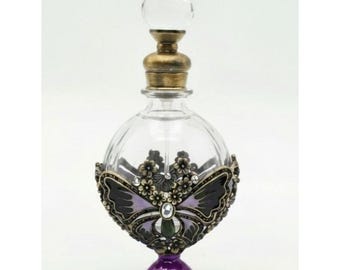 Frasco de perfume vintage em vidro com borboleta, detalhes em cristal e acabamento em bronze.