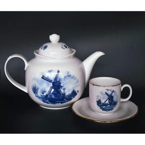 Set da tè, tazza e piattino in porcellana di Delft blu e bianca con motivo a mulino a vento e dettagli dorati, ispirato allo stile olandese.