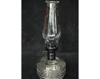 Lámpara de aceite de cristal vintage con base de metal ornamentada, 20 cm de altura, pieza decorativa funcional.