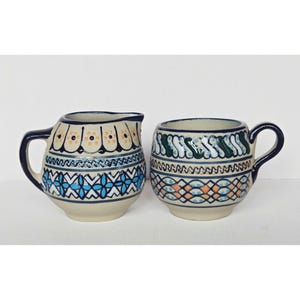 Set composto da lattiera e tazza in ceramica messicana CS dipinte a mano con dettagli in rilievo.