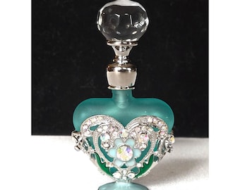 Frasco de perfume vintage de cristal color turquesa con forma de corazón, detalles de diamantes de imitación y tapón de cristal.