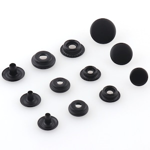 Puede incluir: Surtido de botones a presión de metal negro en varios tamaños. Los botones a presión se utilizan para ropa, manualidades y otros proyectos.