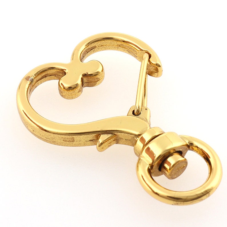 May include: Gold-toned heart-shaped metal key chain with a swivel clasp and a ring.
