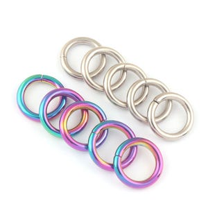 Può includere: Un set di anelli aperti argentati e iridescenti. Gli anelli aperti argentati sono semplici, mentre gli anelli aperti iridescenti hanno una finitura arcobaleno.