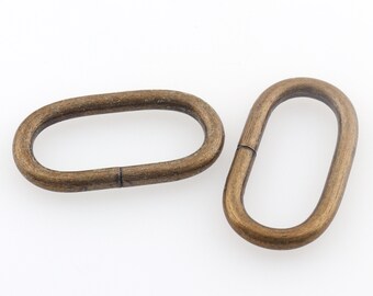 May include: Two antique gold oval metal rings. The rings are smooth and have a slightly rounded edge.