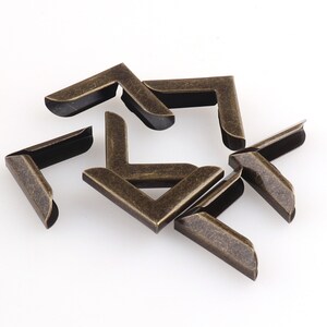 May include: A set of eight antique gold corner protectors. These metal corner protectors are ideal for protecting the edges of books, photo albums, and other items.