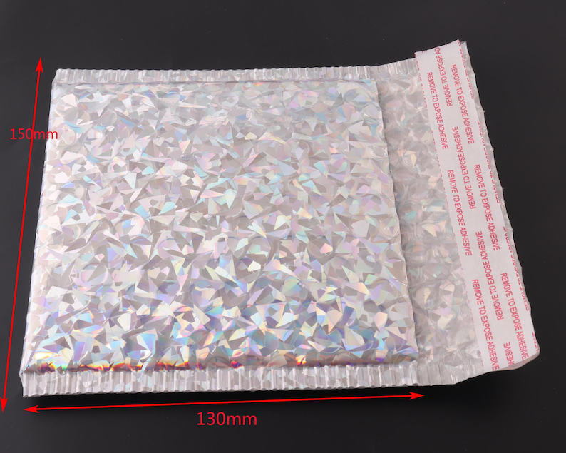May include: A silver iridescent padded mailing envelope with a peel-and-seal adhesive strip. The envelope measures 130mm by 150mm.