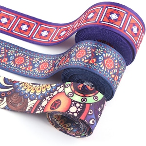 May include: Three rolls of colourful patterned ribbon. The ribbon is blue with red and white designs. The designs include geometric shapes, flowers, and abstract patterns.