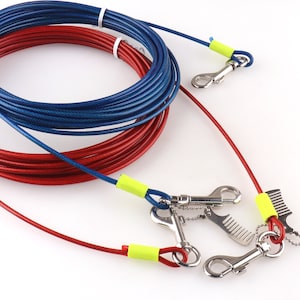 May include: Two red and blue retractable dog leads with yellow and blue clips. The leads are coiled and ready to be used.