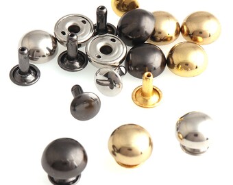 Puede incluir: Surtido de remaches metálicos en oro, plata y negro. Los remaches son de varios tamaños y formas, algunos con la parte superior abovedada y otros con la parte superior plana.