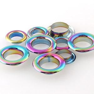 Op de afbeelding: Assortiment van regenboogkleurige metalen oogjes in verschillende maten.