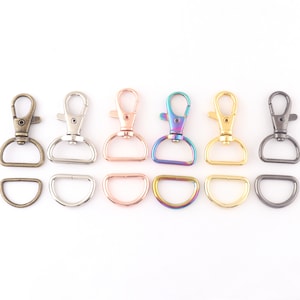 May include: Set of six metal swivel clasps and matching D-rings in various finishes, including antique brass, silver, rose gold, rainbow, gold, and black.