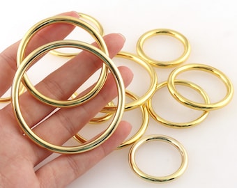 Op de afbeelding: Een set gouden metalen ringen in verschillende maten. De ringen zijn glad en hebben een gepolijste afwerking.