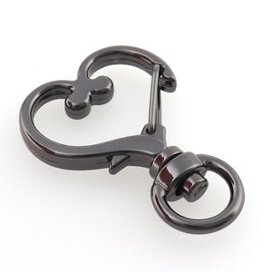May include: Black metal heart-shaped swivel clasp with a spring-loaded gate. The clasp has a round ring on one side and a heart-shaped loop on the other.