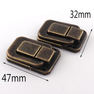 Puede incluir: Dos cierres de caja de color bronce antiguo, cada uno mide 47 mm por 32 mm. Los cierres tienen una forma rectangular con una tapa con bisagras y un pestillo.