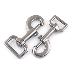 Puede incluir: Dos mosquetones giratorios de metal plateado. Uno tiene un ojo rectangular y el otro un ojo redondo. Ambos tienen una puerta con resorte para una fijación segura. Ideal para diversos proyectos de artesanía y ferretería.
