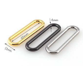 May include: Three oval-shaped metal rings in gold, black, and silver. The rings are 50mm long and 4mm wide.