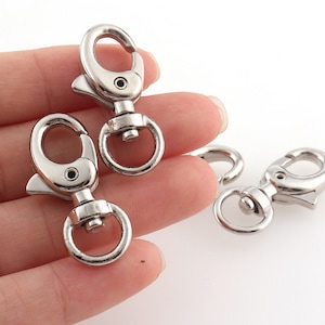 May include: Three silver metal trigger snap hooks. The hooks have a spring-loaded gate and a D-ring.