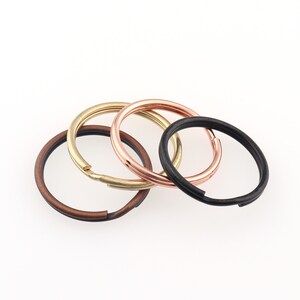 May include: Four key rings in different colors: copper, gold, rose gold, and black.