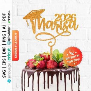 May include: A gold glitter cake topper with the name "Marisa" and the year "2026" in a script font, topped with a graduation cap. The cake is decorated with chocolate ganache and fresh strawberries.