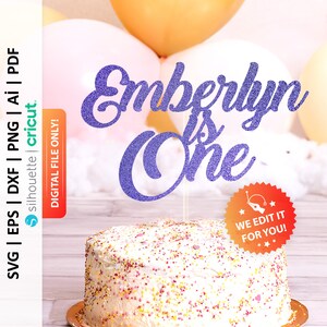 May include: Purple glitter cake topper with the text "Emberlyn is One" in a cursive font. The topper is on top of a white cake with pink and yellow sprinkles.